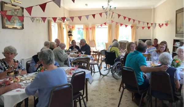 Residents Enjoying Afternoon Tea With Friends And Family In The Dining Room