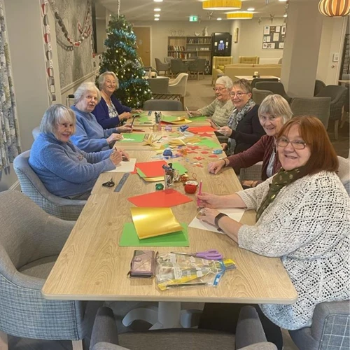 Table of men and women taking part in Xmas craft activities