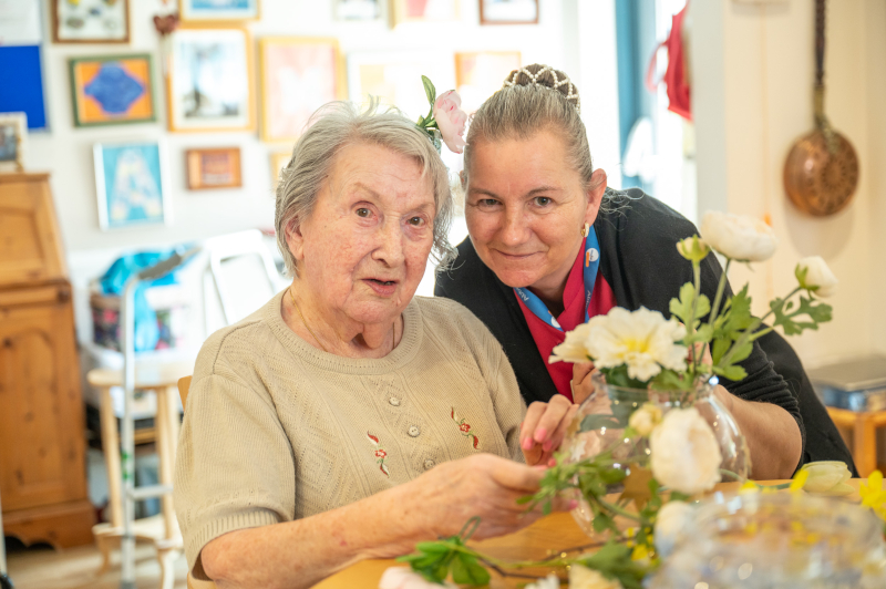 Resident And Staff Member Enjoying Some Flower Arranging Together