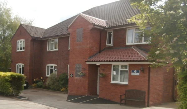 The front of the house with a bench under the window