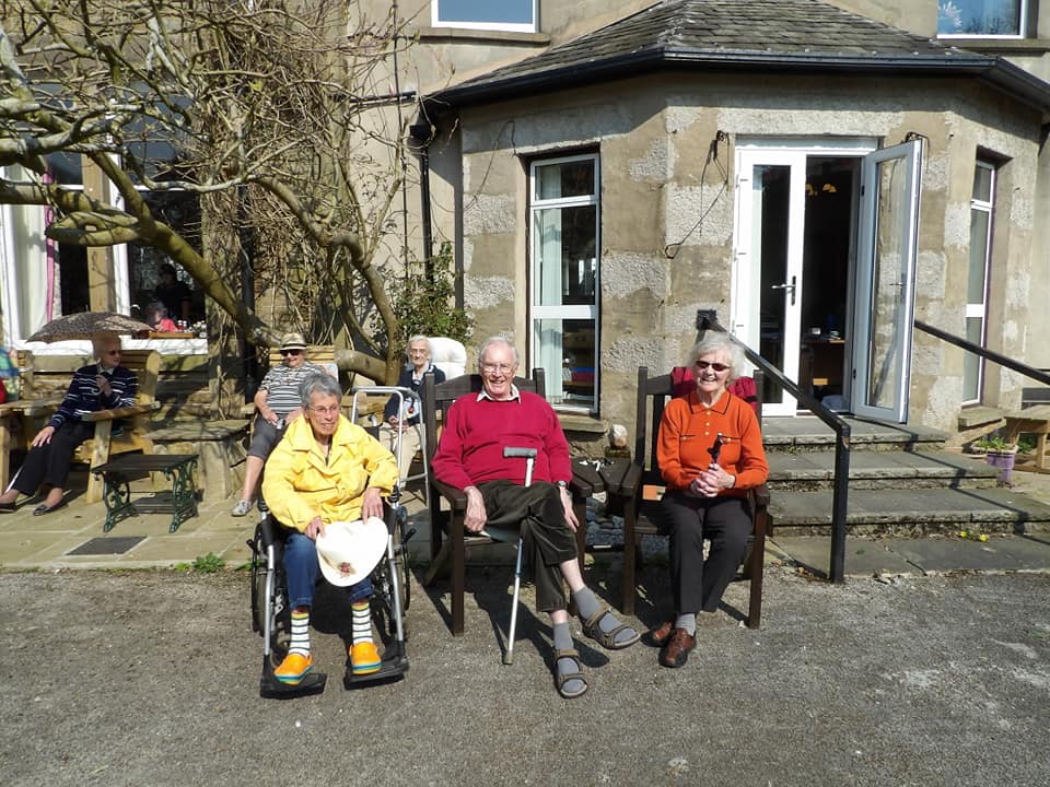 Residents are sat outside the Cove House in the sun