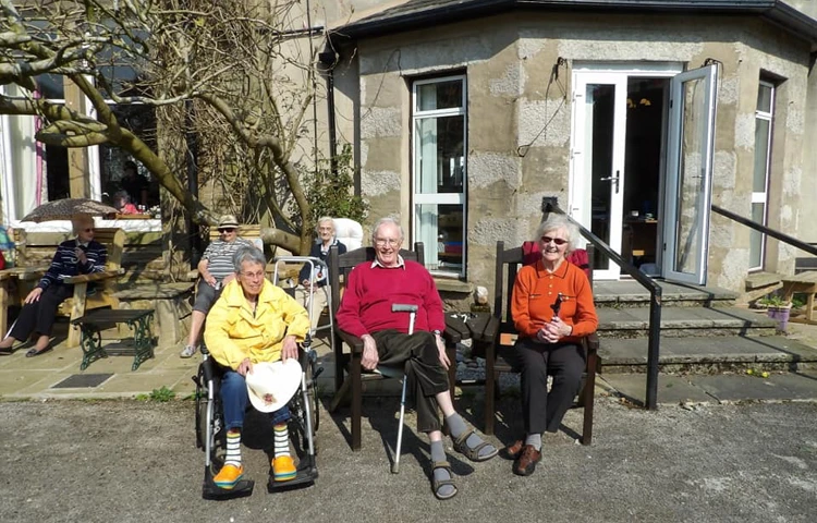 Residents are sat outside the Cove House in the sun