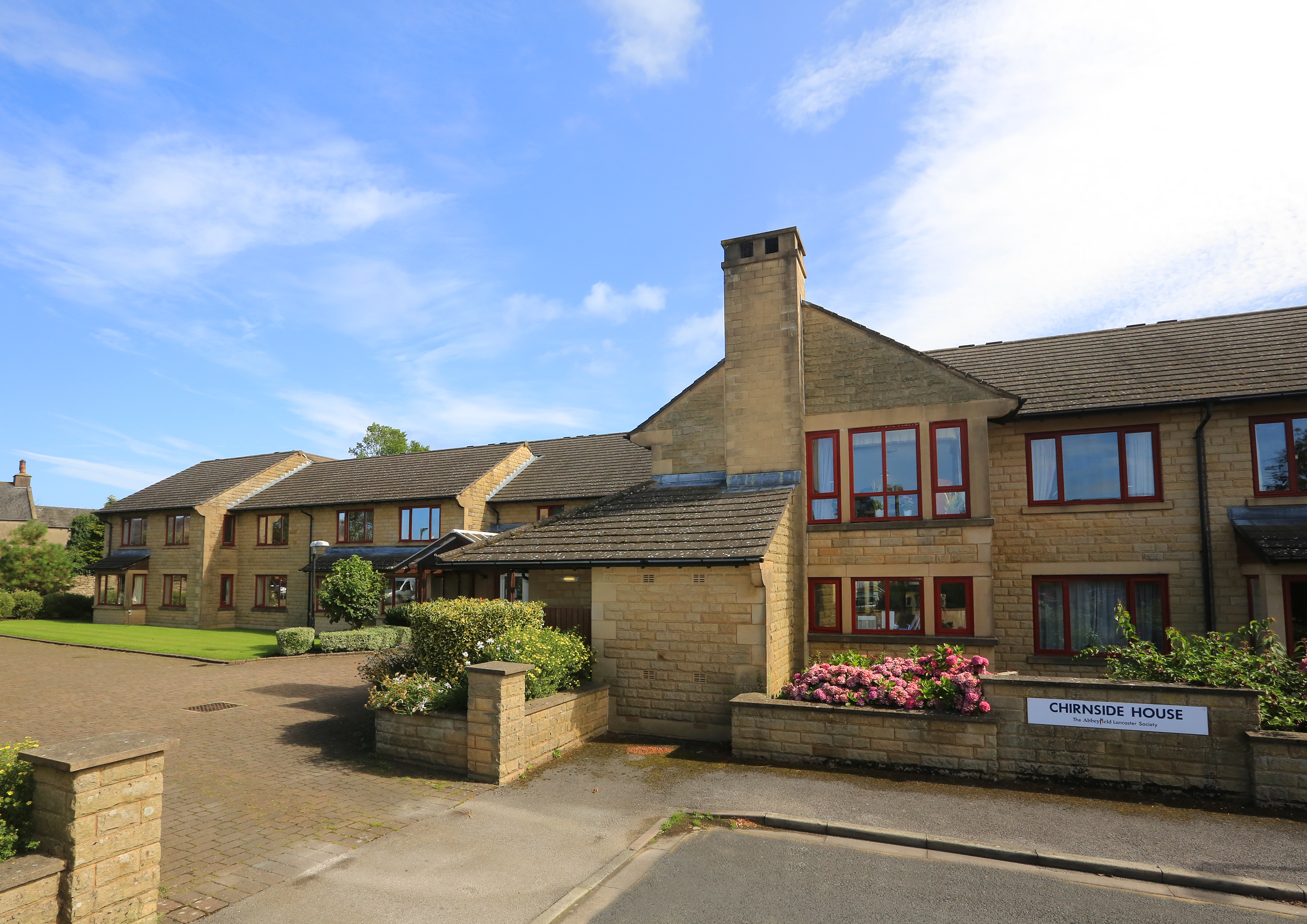Chirnside house with short garden wall and bright flowers