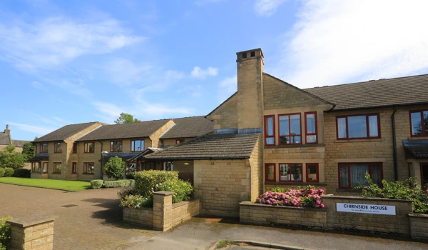Chirnside house with short garden wall and bright flowers