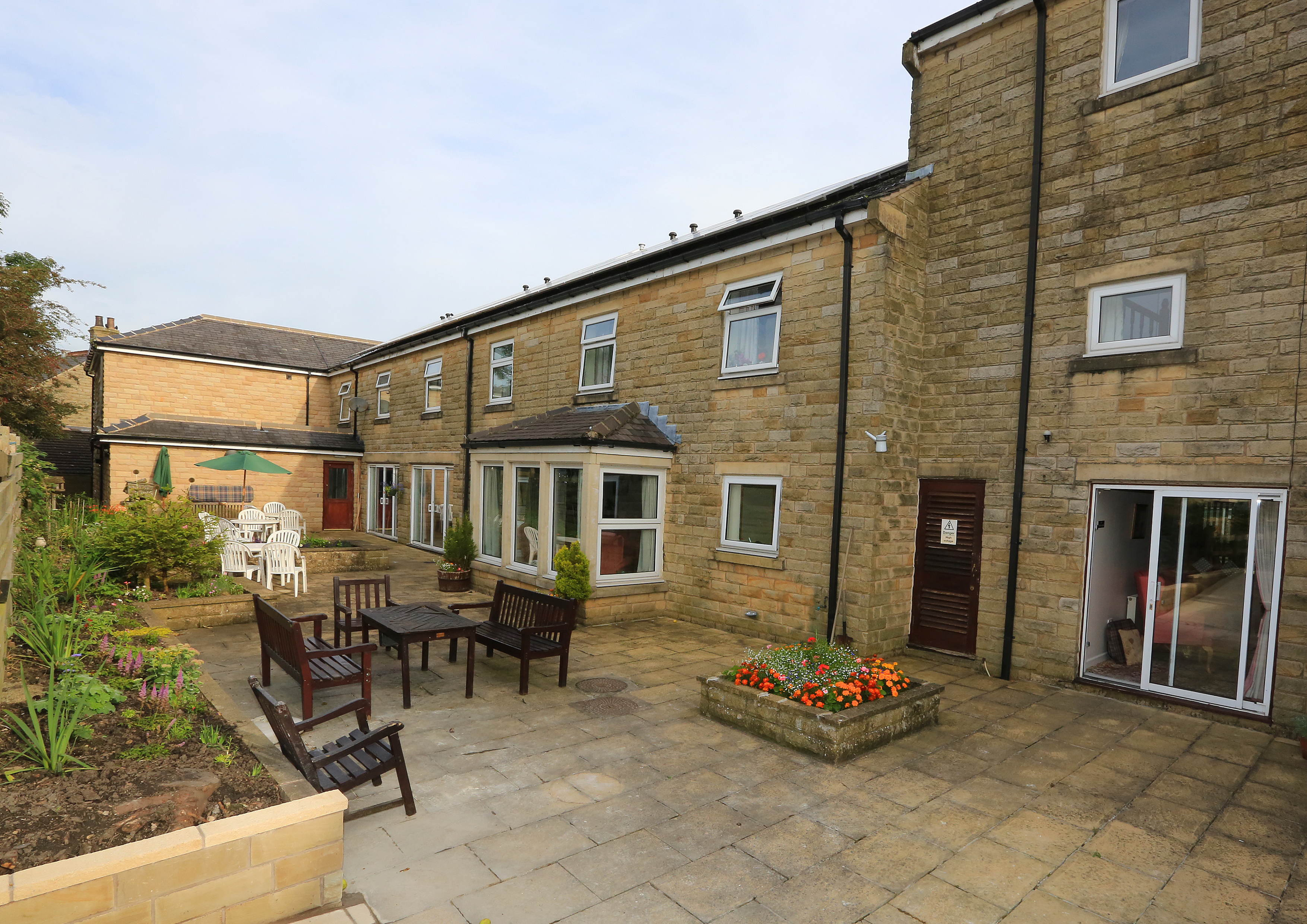 External view of paved courtyard and seating at Abbeyfield House, Clitheroe, BB7 2NH