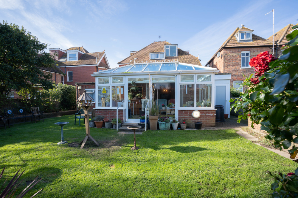 Outside view of the sunny garden and conservatory at Beachside House