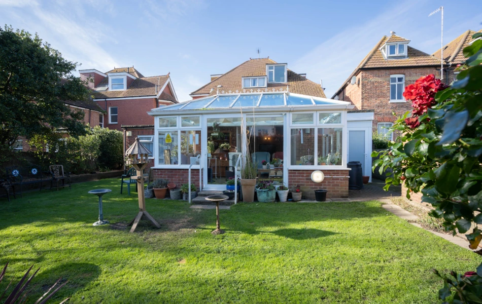 Outside view of the sunny garden and conservatory at Beachside House
