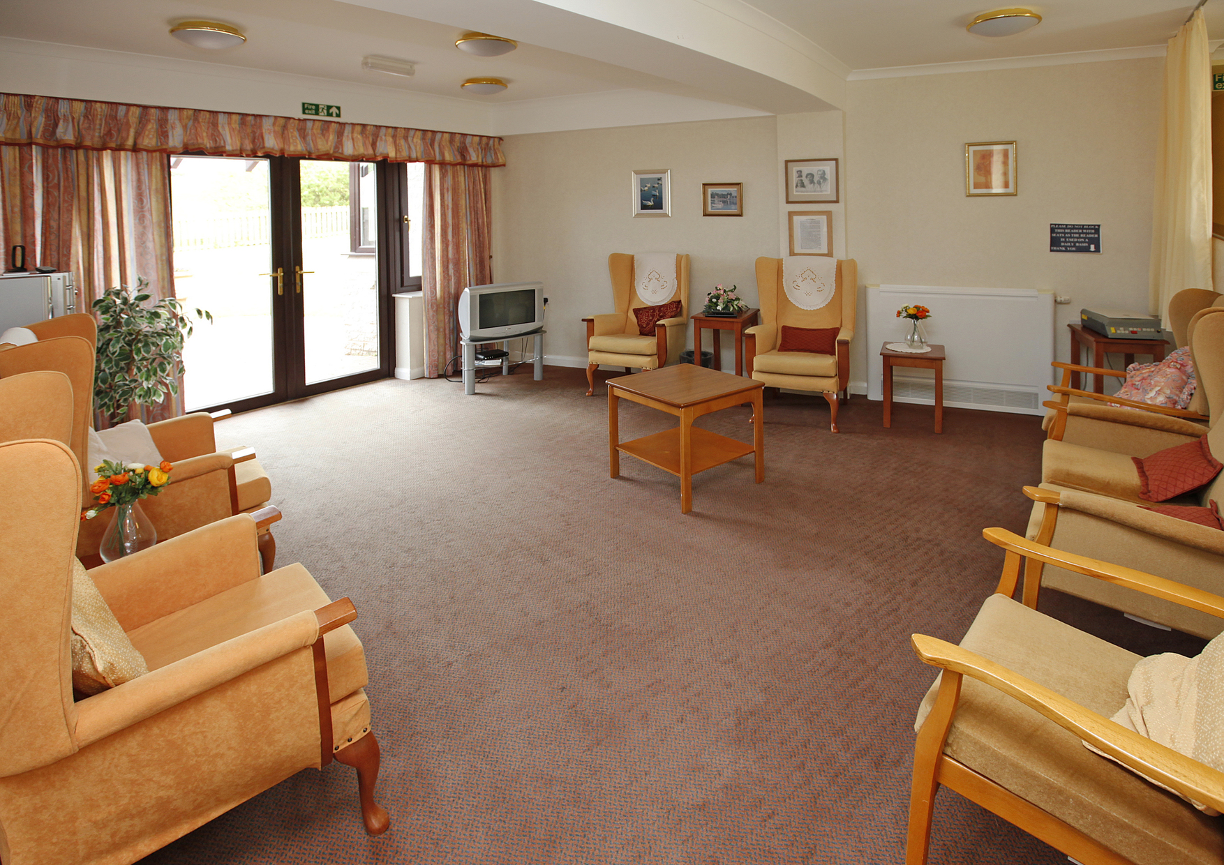 Spacious lounge with bright chairs and a television at Staveley House