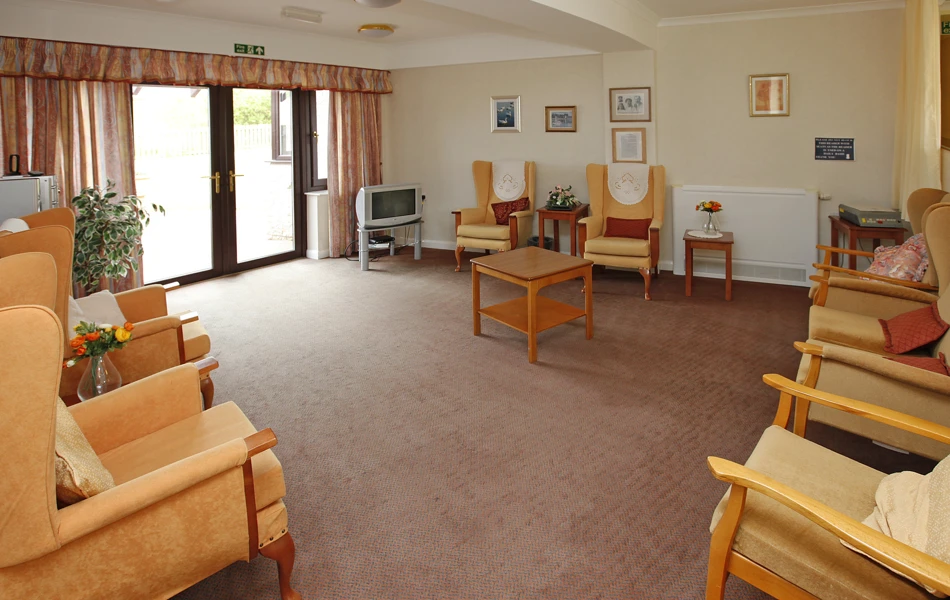 Spacious lounge with bright chairs and a television at Staveley House