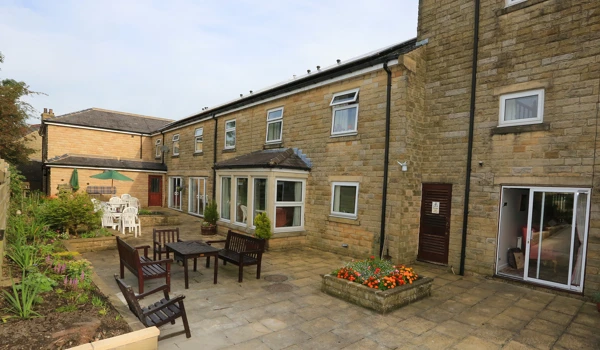 External view of Abbeyfield House Clitheroe with paved courtyard and seating