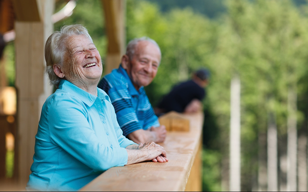 Older Man And Woman Smiling And Laughing On Balcony