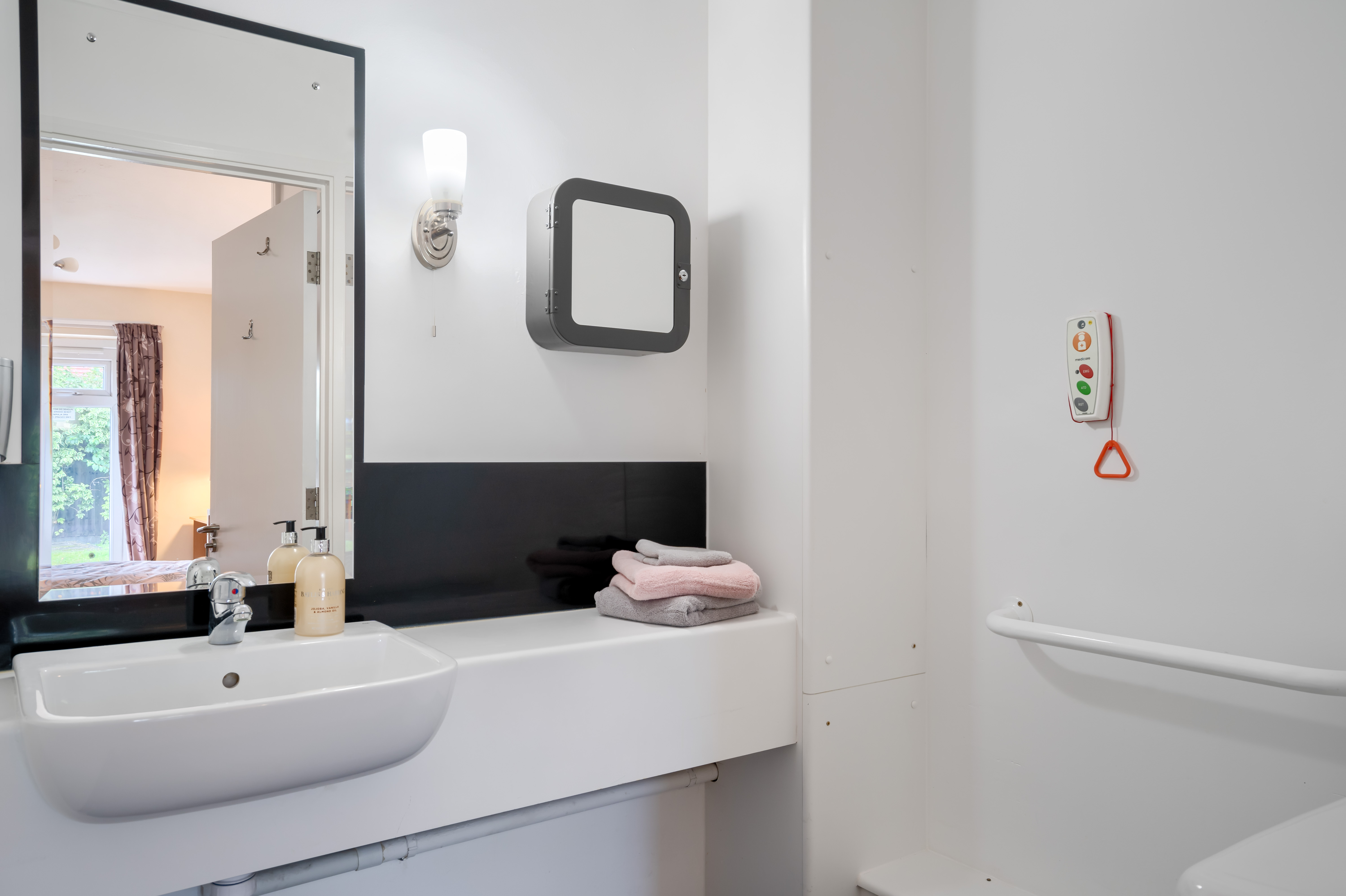 En-suite bathroom with mirror at Halcyon House Care and Nursing Home