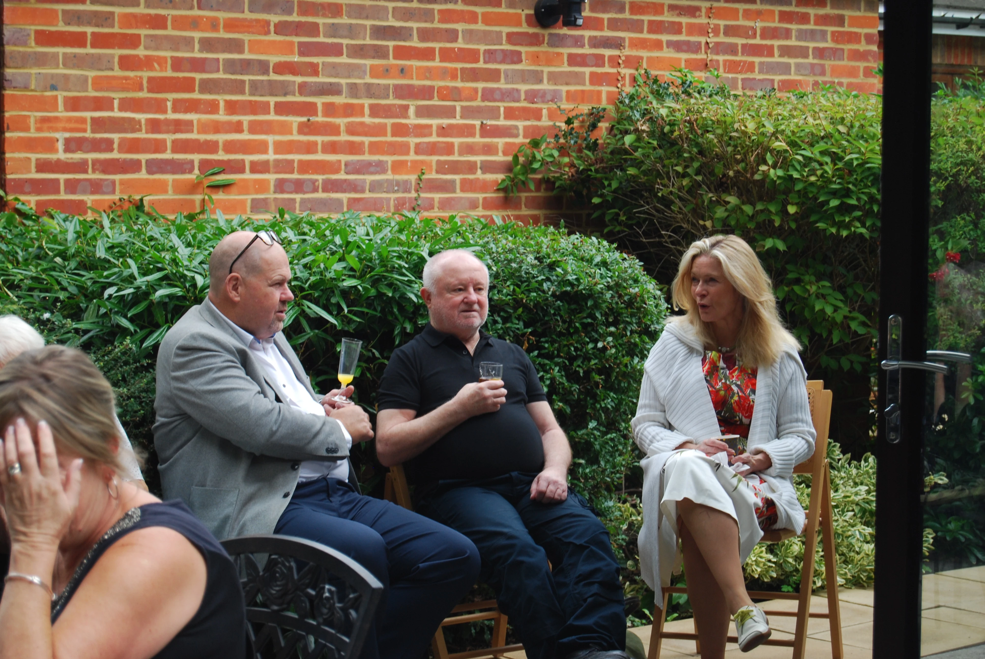 Three people sitting in the garden talking