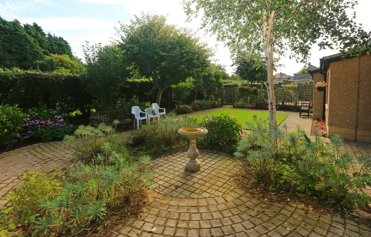 Outside garden area with paved patio and bird bath at Chirnside House