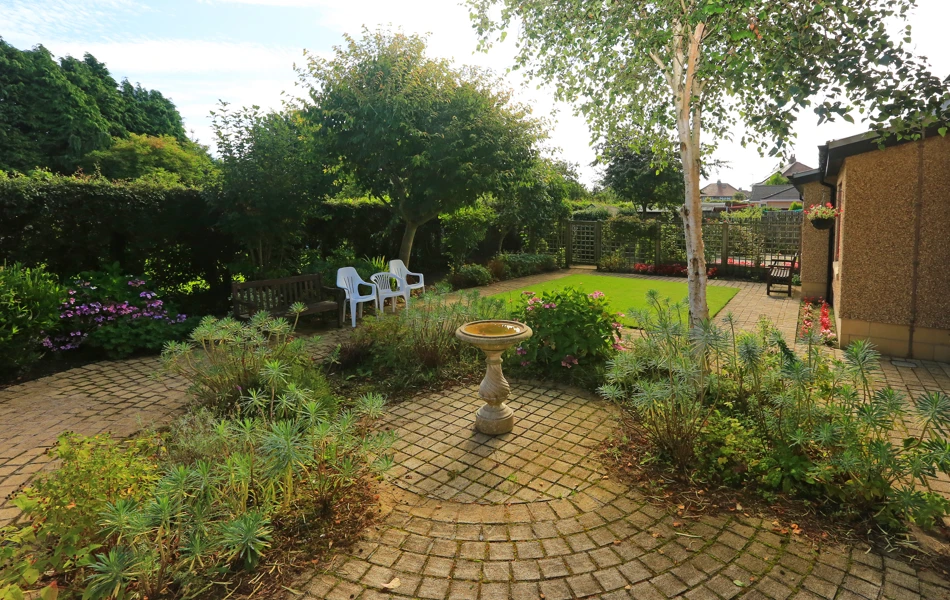 Outside garden area with paved patio and bird bath at Chirnside House