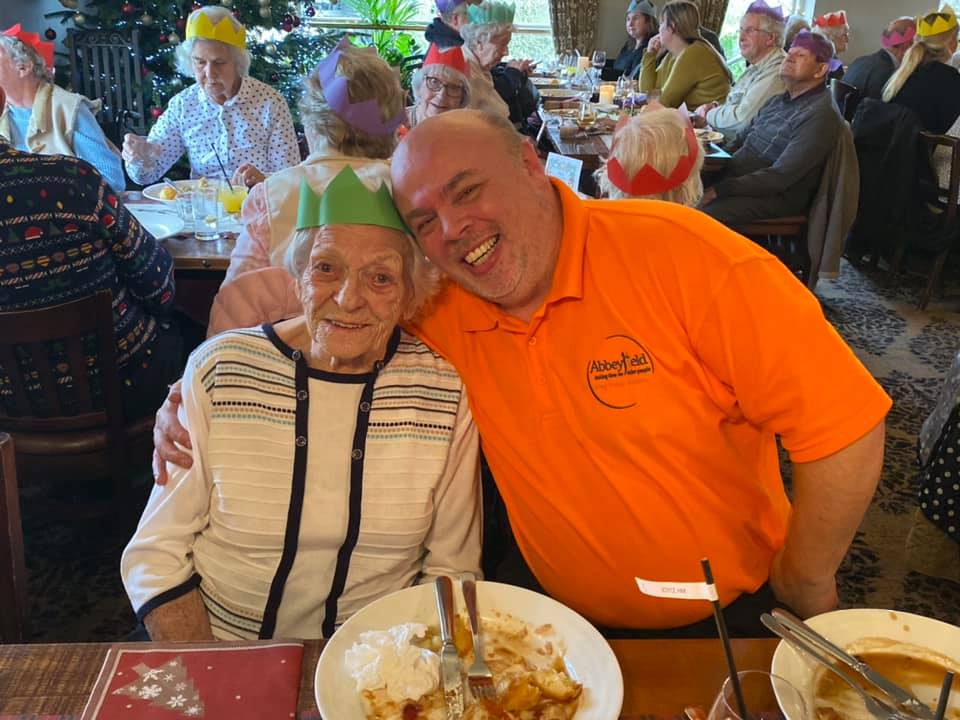 Resident and member of staff enjoying christmas dinner together at Hatch Mill