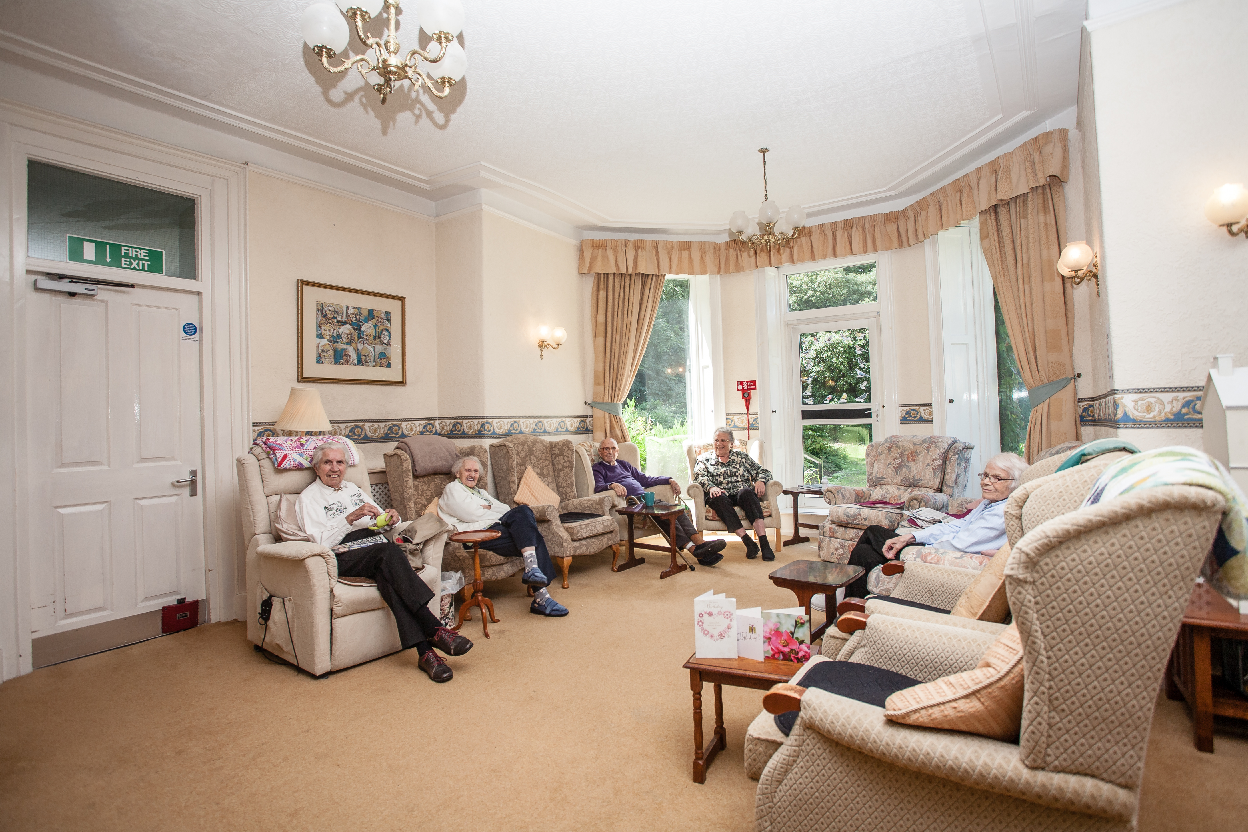 The bright spacious lounge with residents sat together