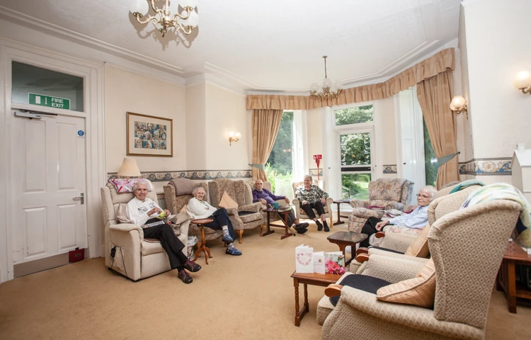 The bright spacious lounge with residents sat together