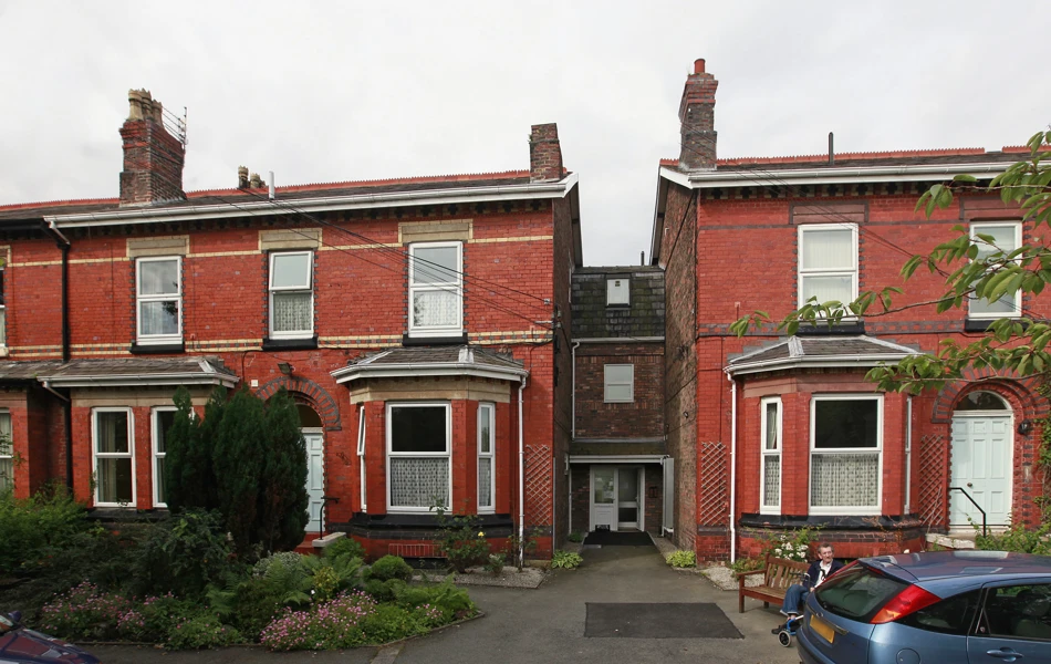 The front of Marsh House with conifers in the front garden