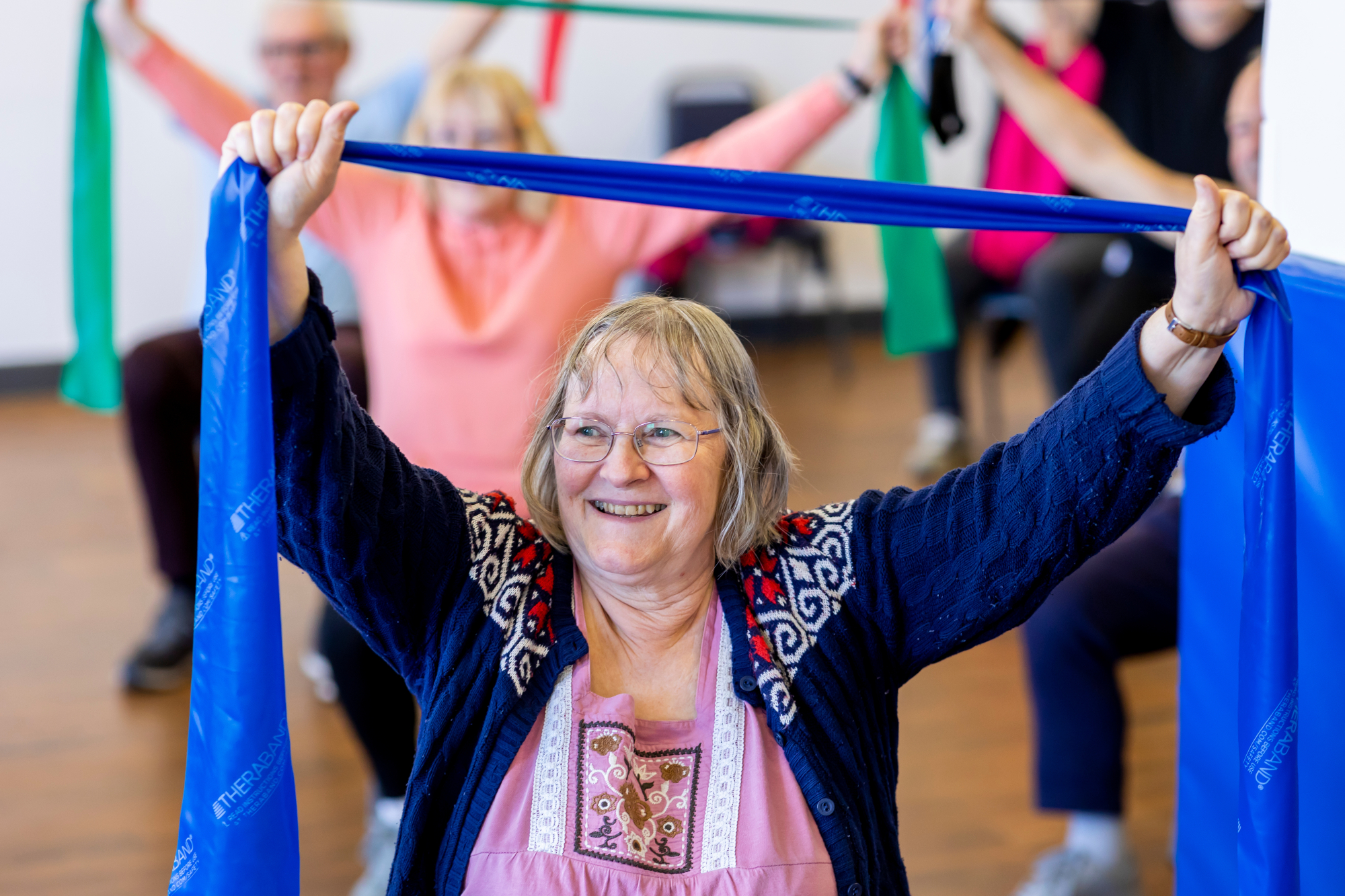 Older Woman Doing Seated Exercise In A Group Class