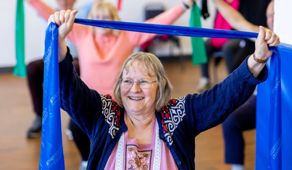Older Woman Doing Seated Exercise In A Group Class