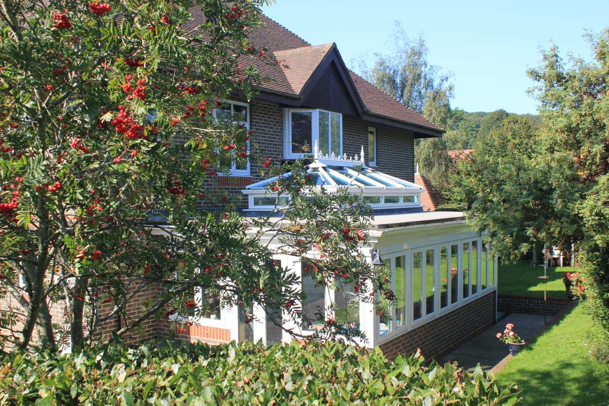 Exterior shot of the back of Abbeyfield House, Alfriston showing trees and conservatory