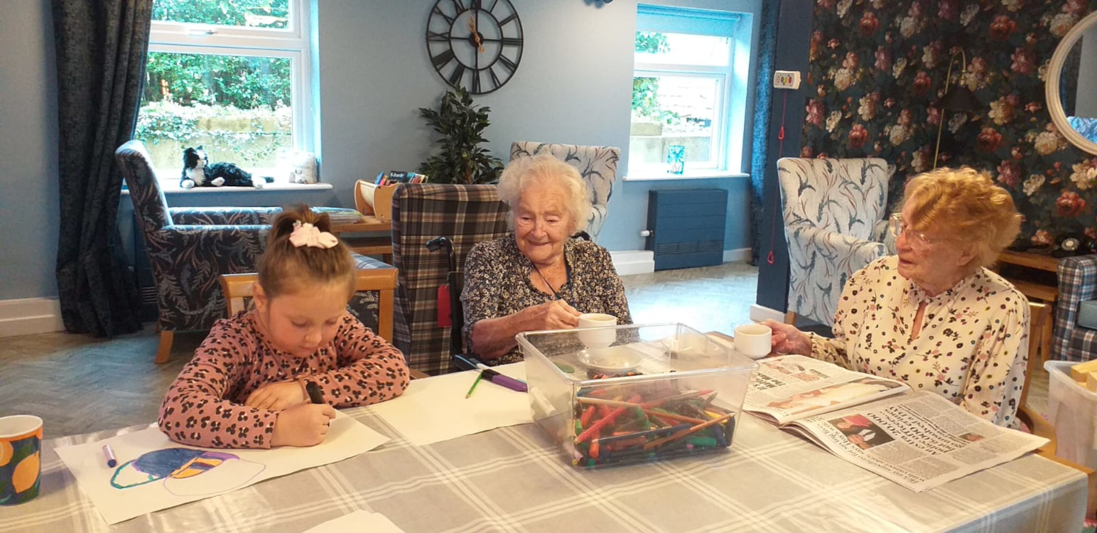 Residents Enjoying A Colouring Session With A Girl