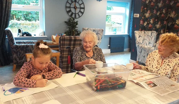 Residents Enjoying A Colouring Session With A Girl