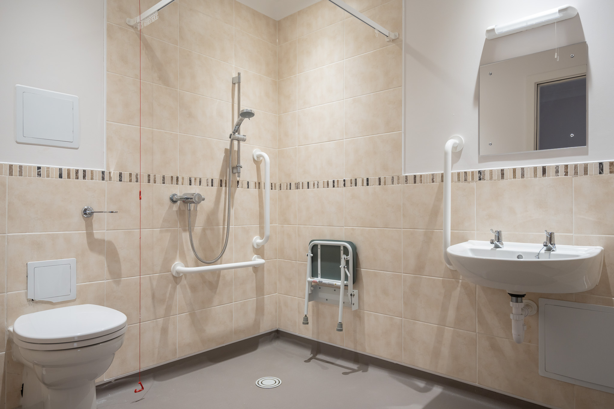 One of our assisted bathrooms with handrails and seating