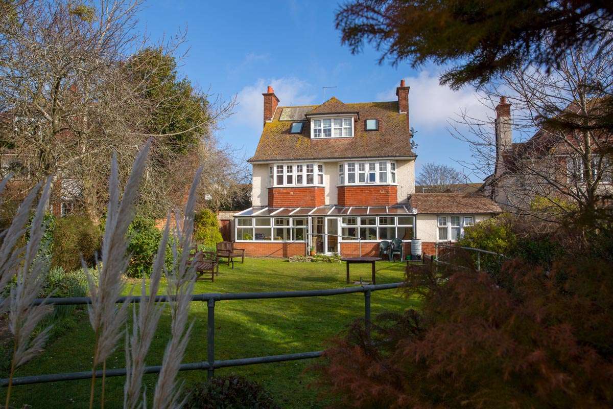 Back exterior of Lade House leading onto large sunny garden where residents can while away the hours in the sun