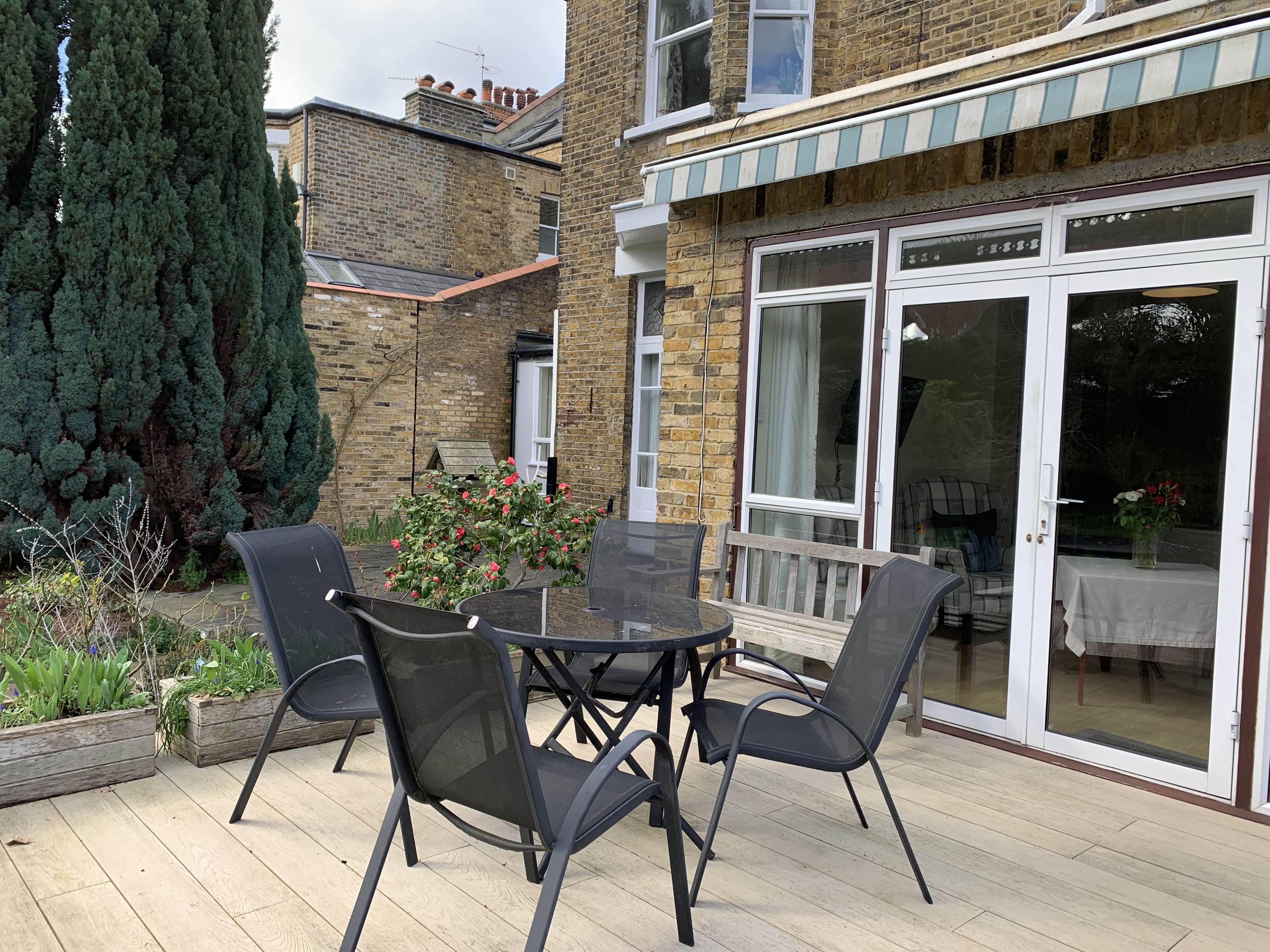 Table and chairs outside on the decking where residents can enjoy the sunshine in the garden