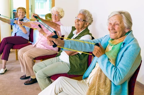 A group of happy women performing seated exercises