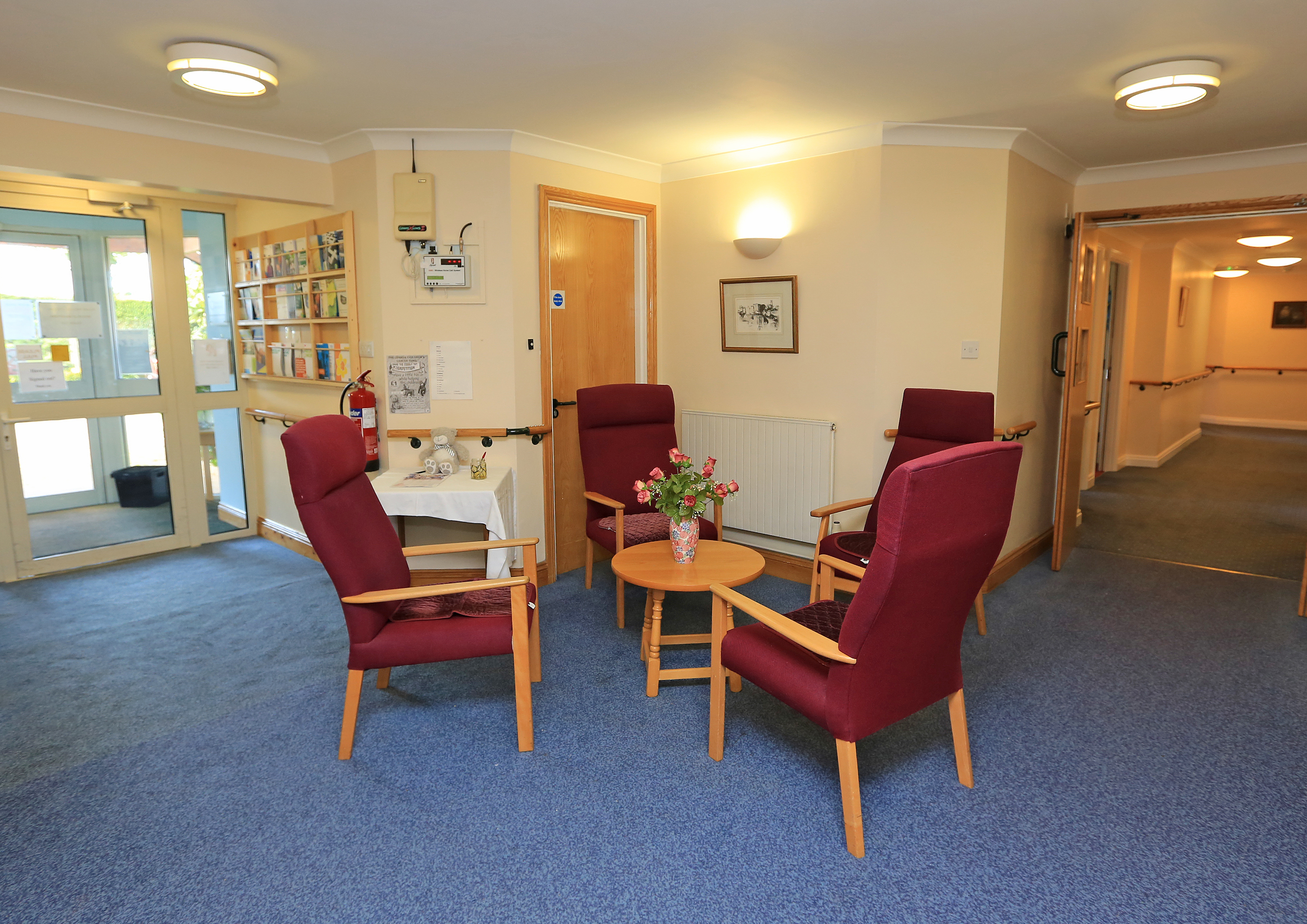 Seating area with dark red chairs and a table at Chirnside House, Lancaster