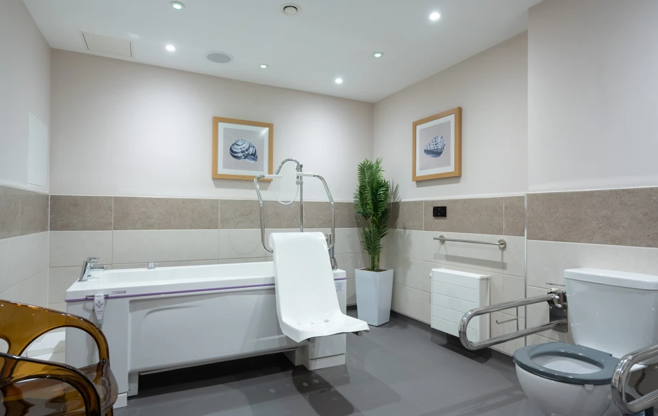 Accessible bathroom at Westall House in Horsted Keynes, featuring a specialised bathtub and support bars