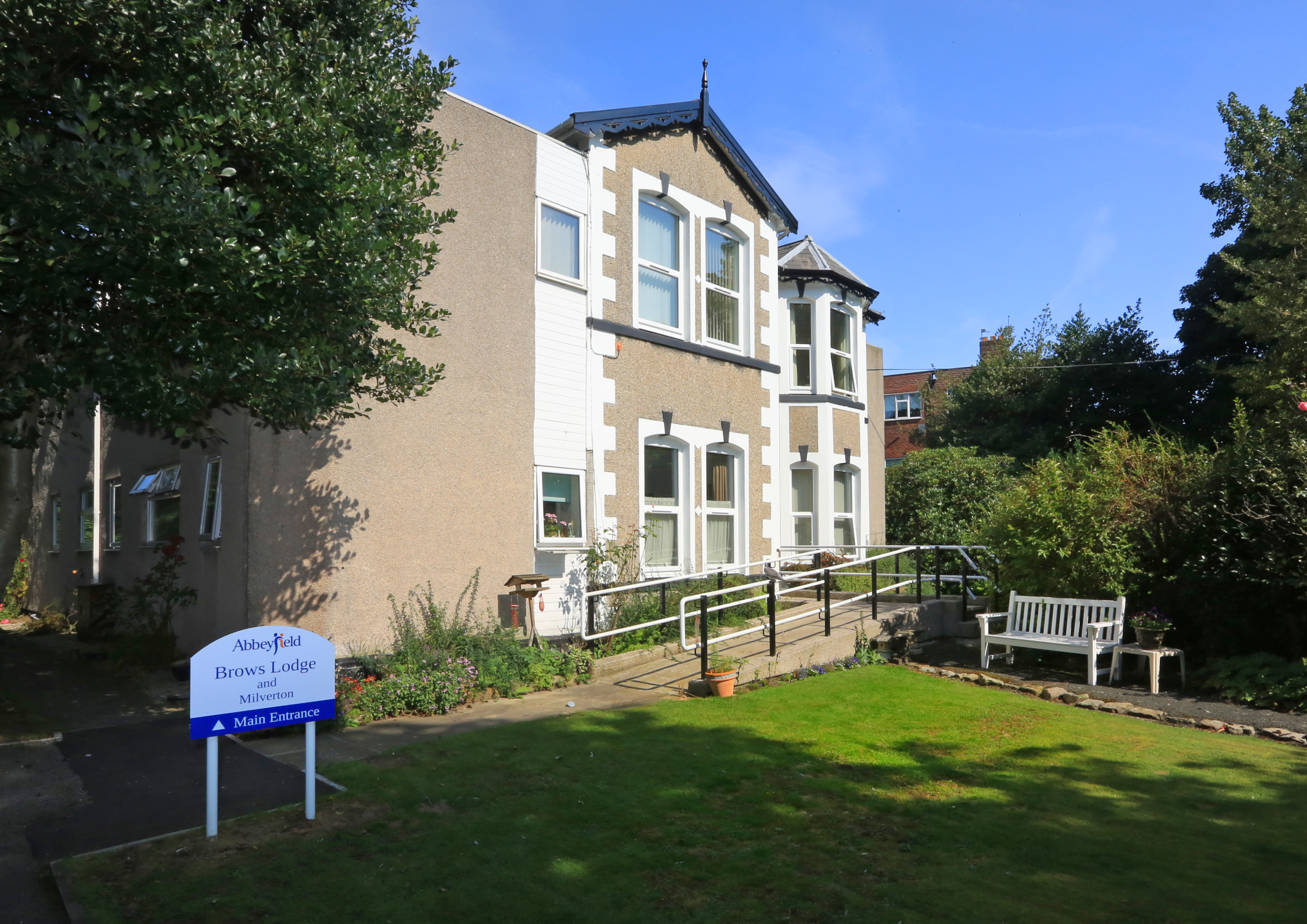 The front of the house with a white bench outside