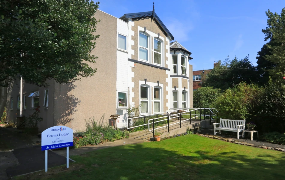 The front of the house with a white bench outside