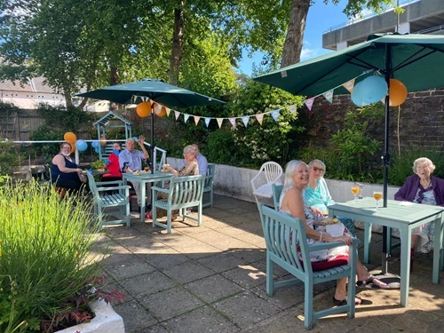 Residents on the patio with bunting and balloons