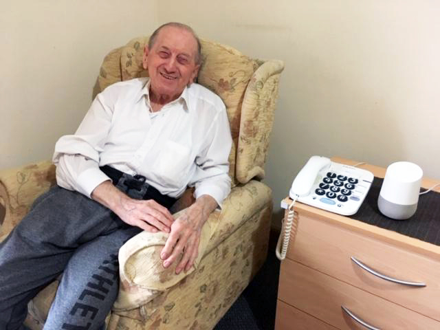 Resident at Maitland House smiling in chair in room