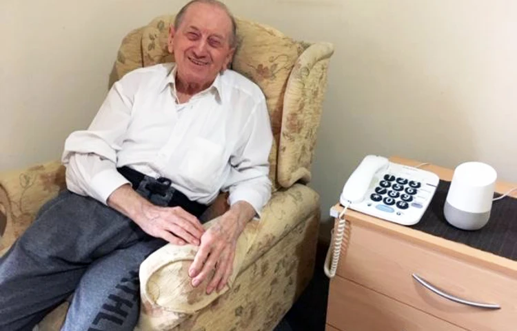 Resident at Maitland House smiling in chair in room