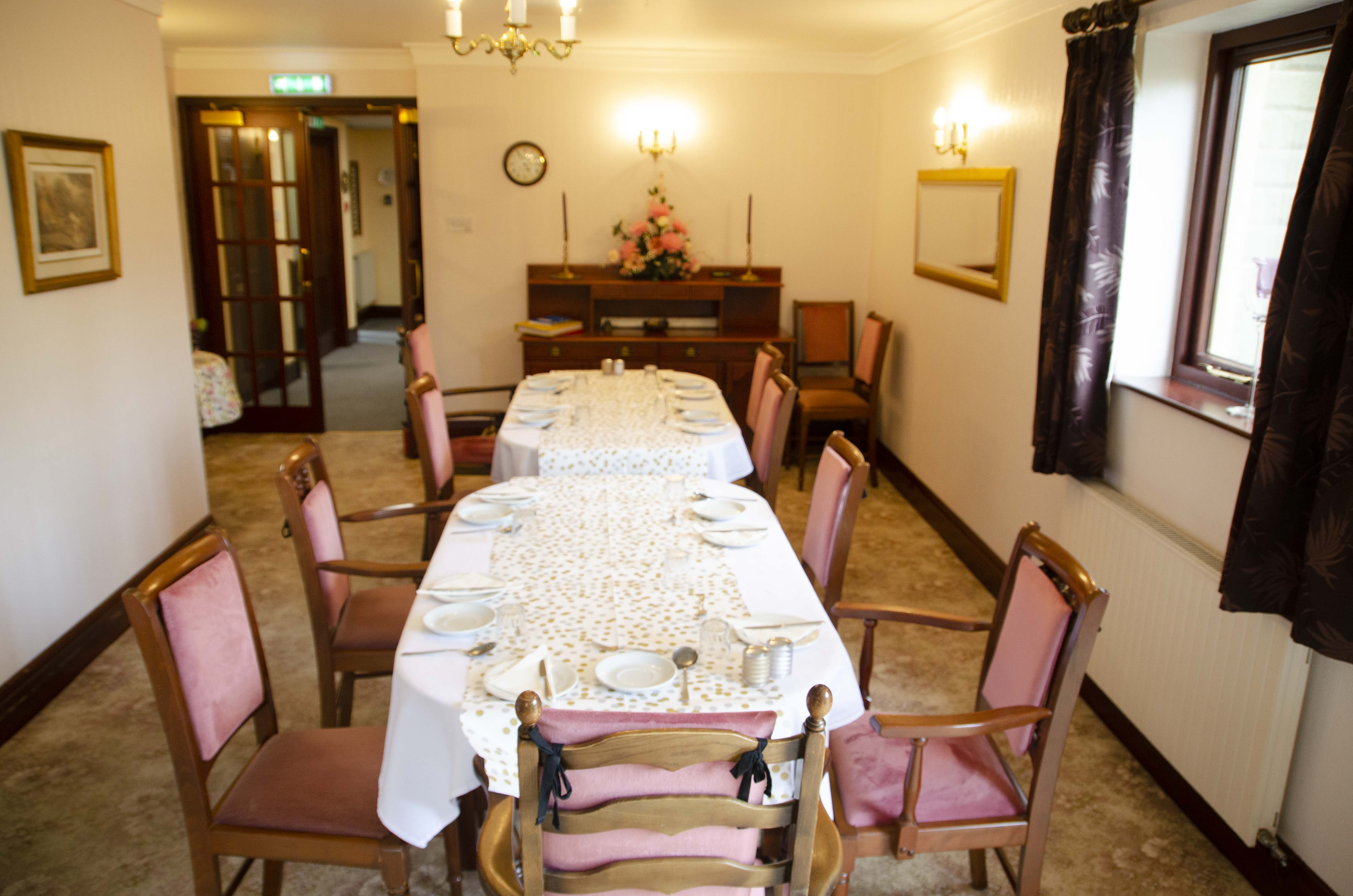 Dining area with long table and pink chairs at Castle View House, BB7 2DT