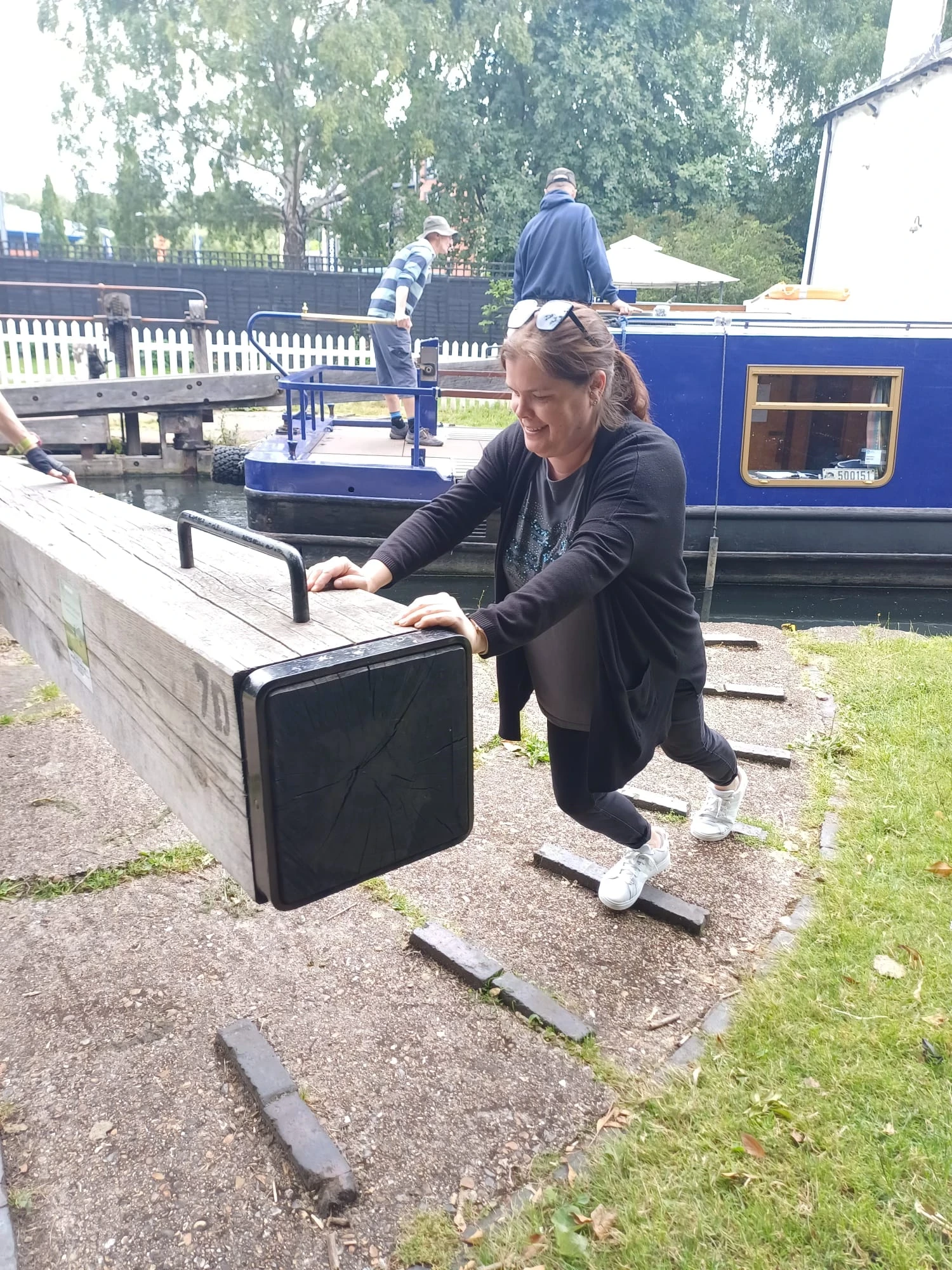 A woman pushing the canal lock gate 
