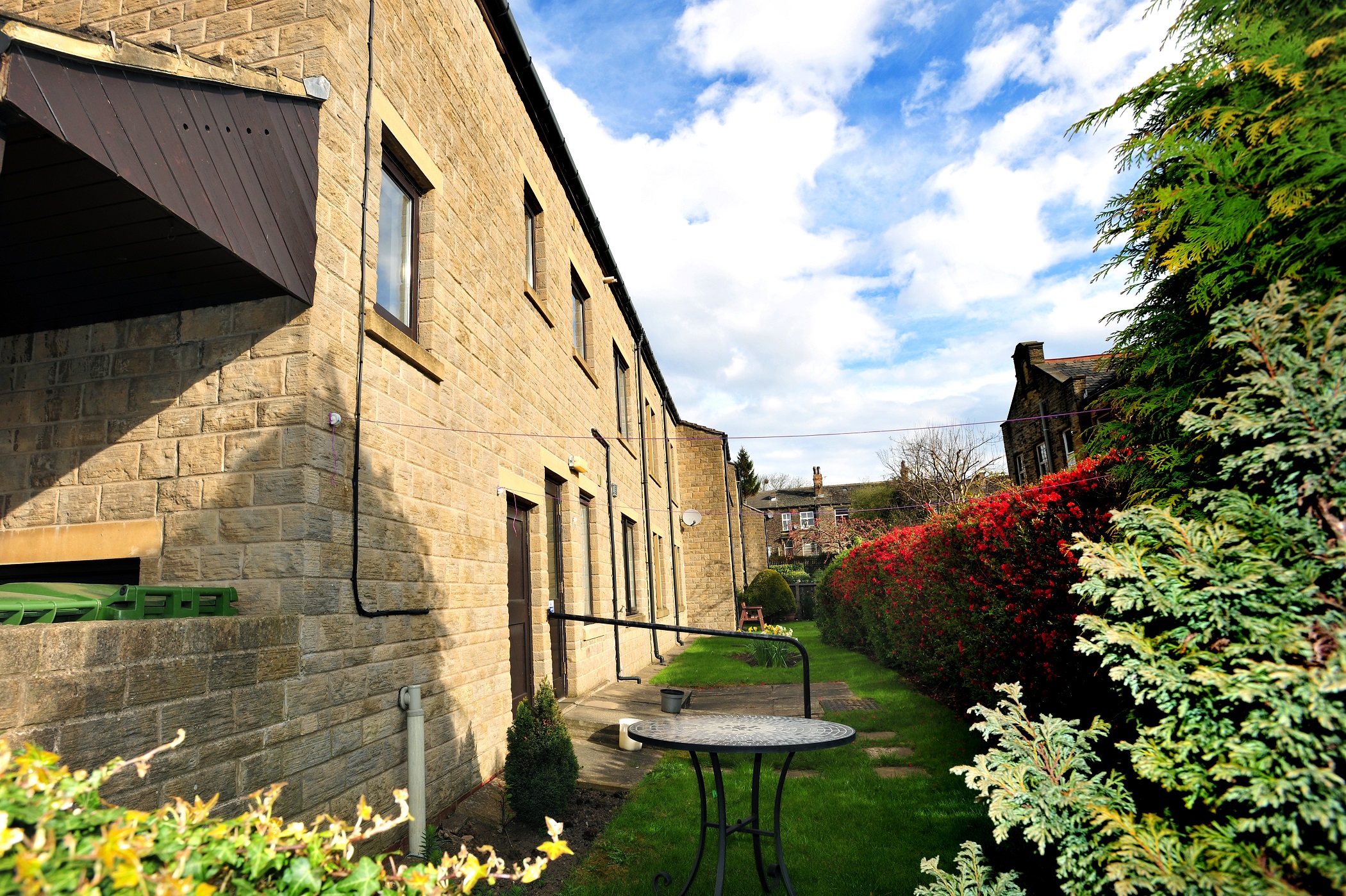 The rear of Abbeyfield House with a table in the garden, independent living in Pudsey