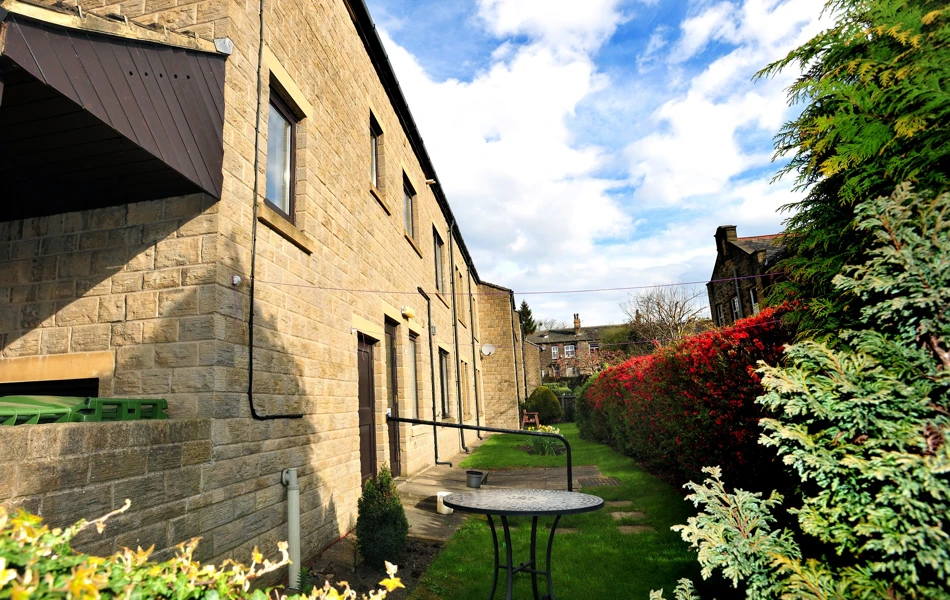 The rear of Abbeyfield House with a table in the garden, independent living in Pudsey