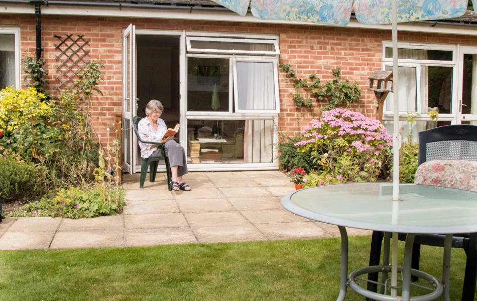 Resident sitting on the patio reading a book in the sunshine at Westgate