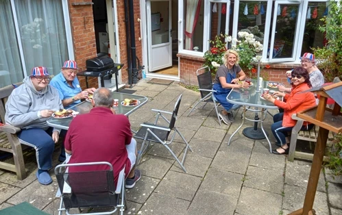 A group of people sitting outdoors enjoying buffet food