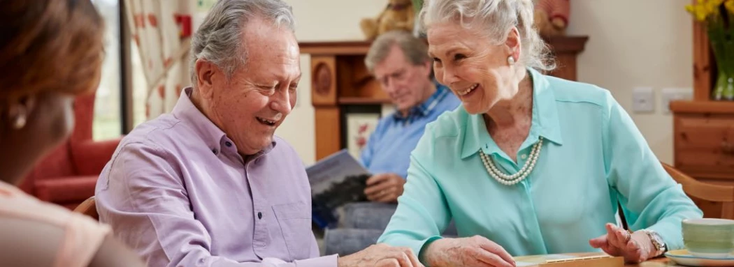 Older Man And Woman Playing A Game At The Table Together