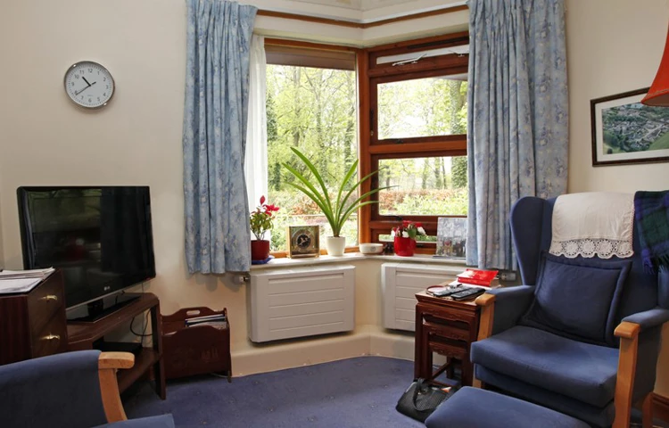 A room with arm chairs and a television