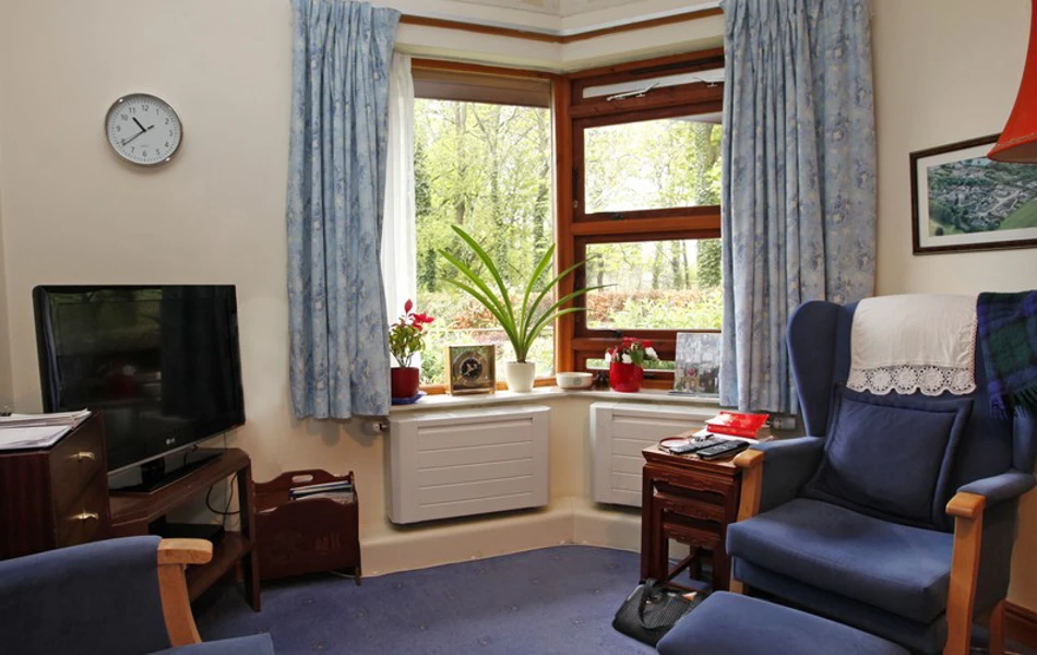 A room with arm chairs and a television