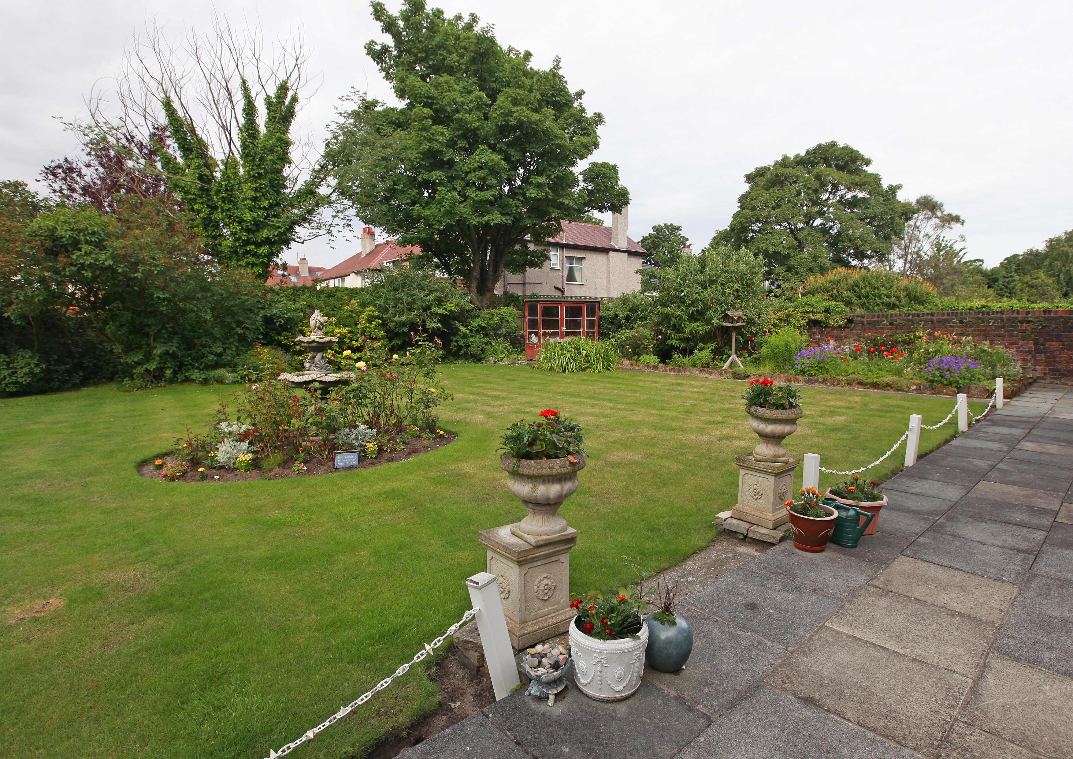 A large garden with stone pillars and flowers