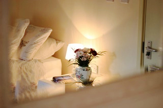 A lit lamp on a bedside table